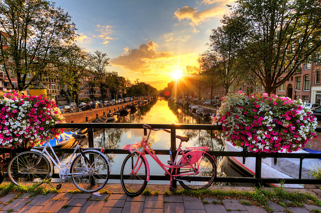 Sunrise over bridge with flowers - Amsterdam Canals Guide
